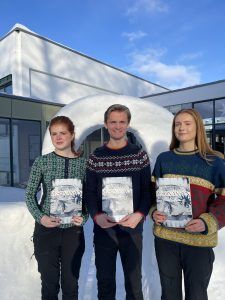 Tre studenter med hver sin skoleavis utendørs