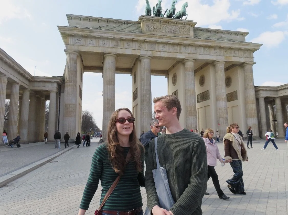 Jente og gutt foran Brandenburger Tor i Berlin